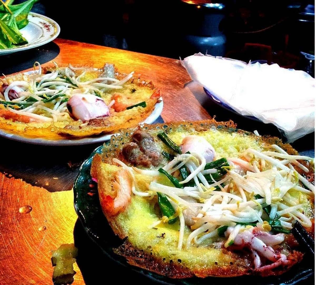 Bánh xèo hải sản giòn rụm với tôm tươi và mực, ăn kèm rau sống và nước mắm pha chua ngọt, đặc sản Phan Thiết hấp dẫn