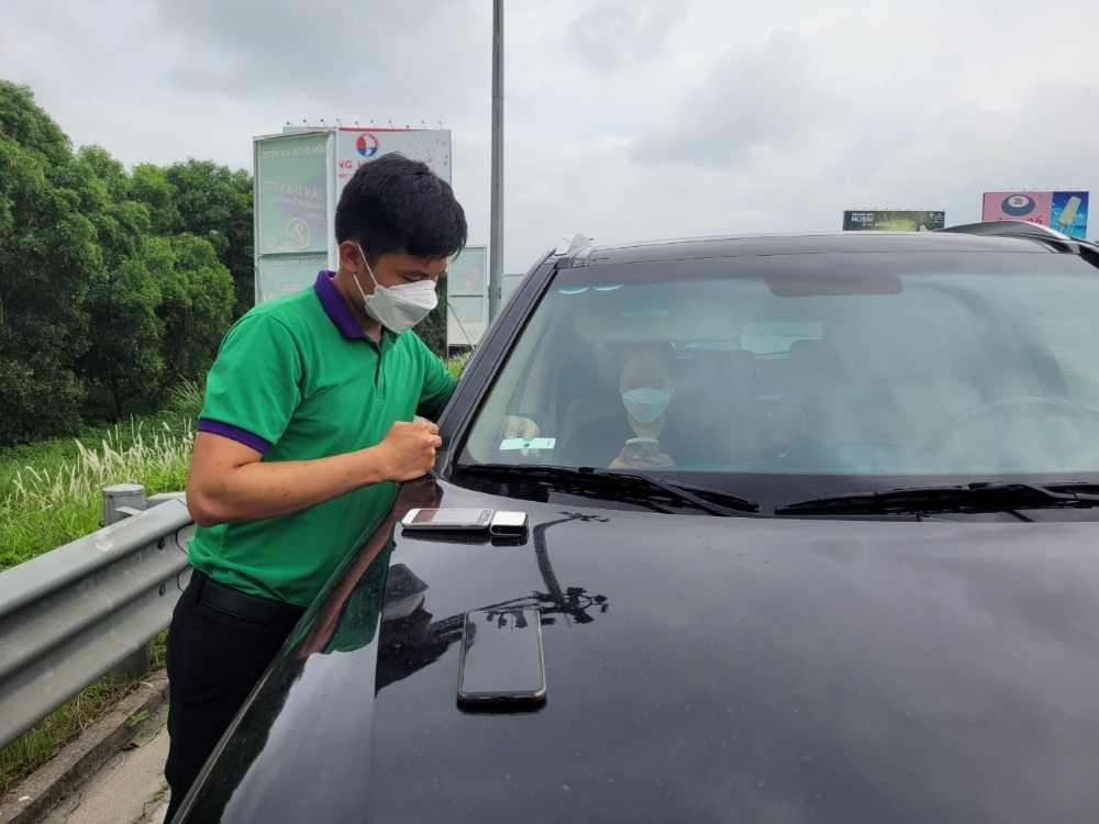 Kỹ thuật viên dán thẻ ePass thu phí không dừng lên kính xe ô tô