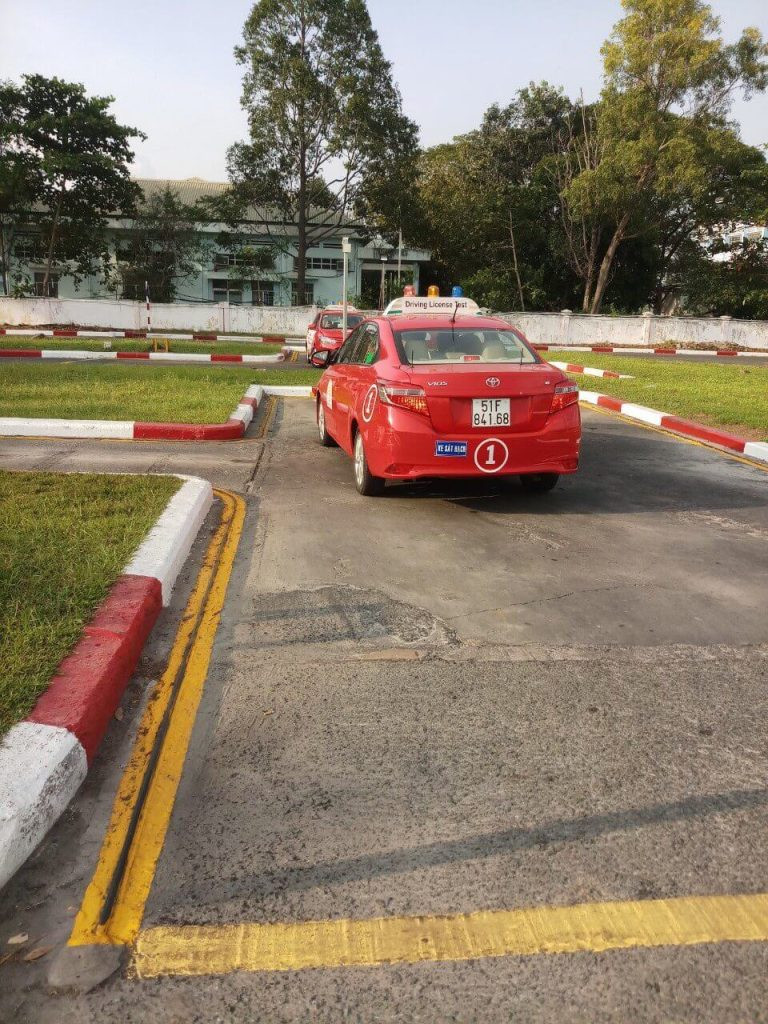 Giáo viên hướng dẫn học viên lái xe ô tô trên sân tập, minh họa thời gian học lái xe ô tô bao lâu