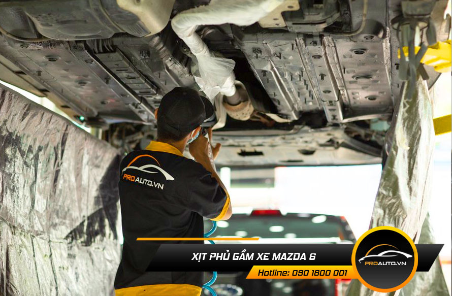 Kỹ thuật viên đang xịt lớp phủ bảo vệ gầm xe Mazda 6, chống ăn mòn và giảm thiểu hư hại từ môi trường.