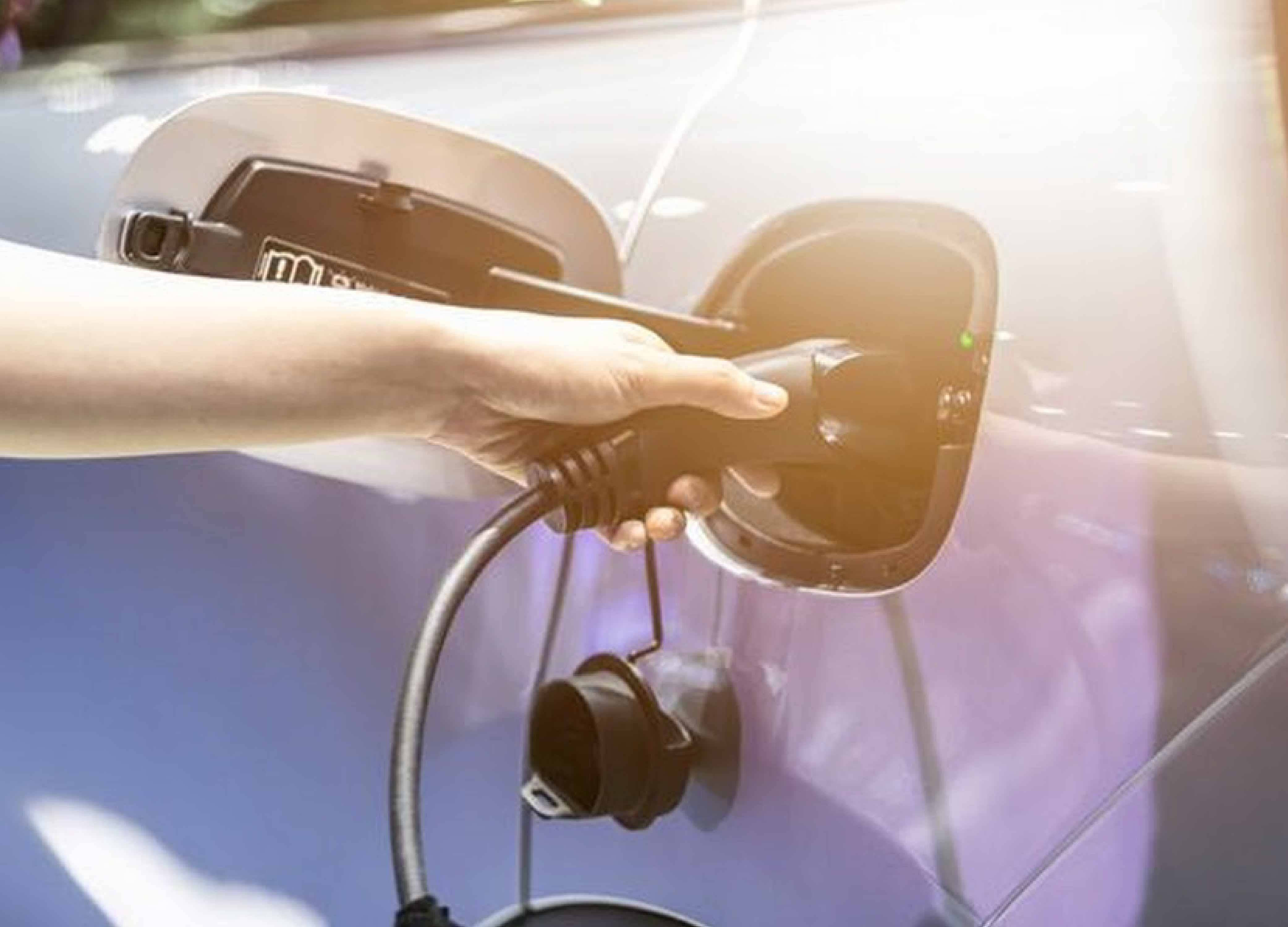 Một chiếc xe ô tô điện đang được sạc tại trạm sạc công cộng, nhấn mạnh sự tiện lợi và xu hướng sử dụng năng lượng sạch cho phương tiện giao thông hiện đại.