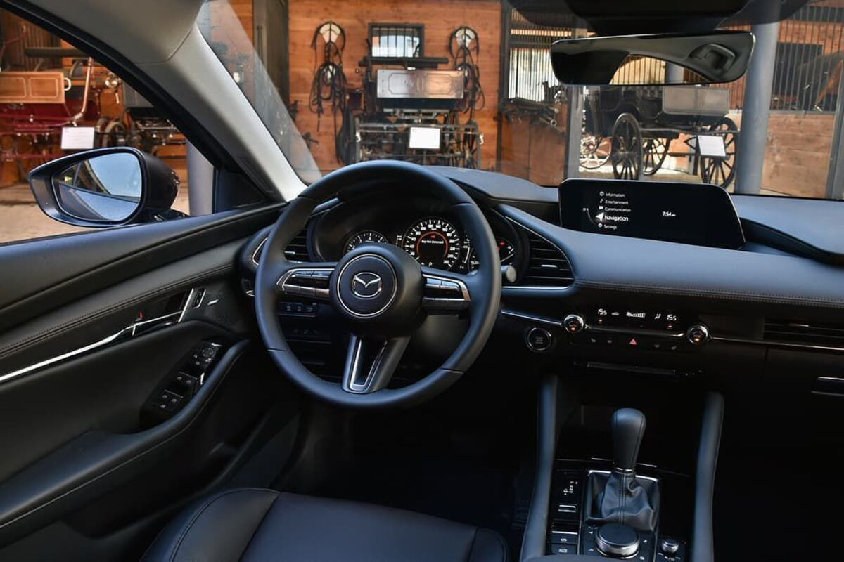 Nội thất ghế lái của Mazda 3 2021 với vô lăng thể thao và màn hình trung tâm rộng